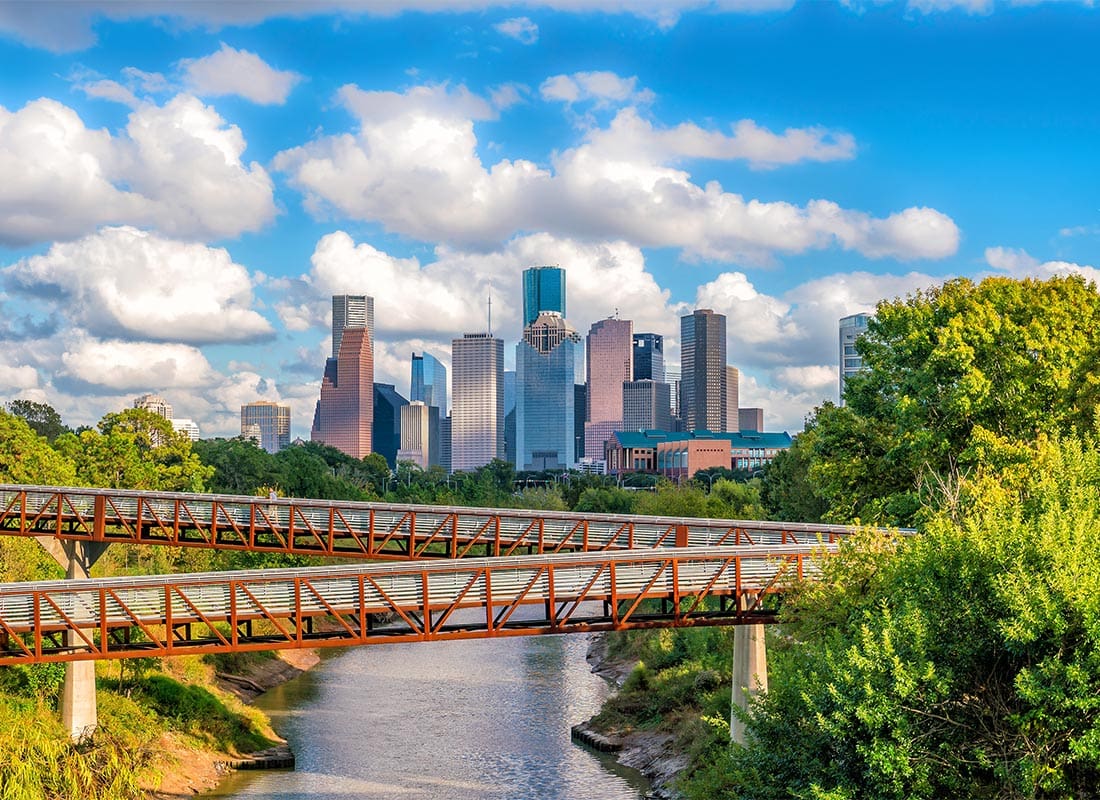 Houston, TX - Downloaded Save to Library Preview Crop Find Similar File #- 134189197 Downtown Houston Skyline With Long Bridge and Lush Trees and Buildings in the Back
